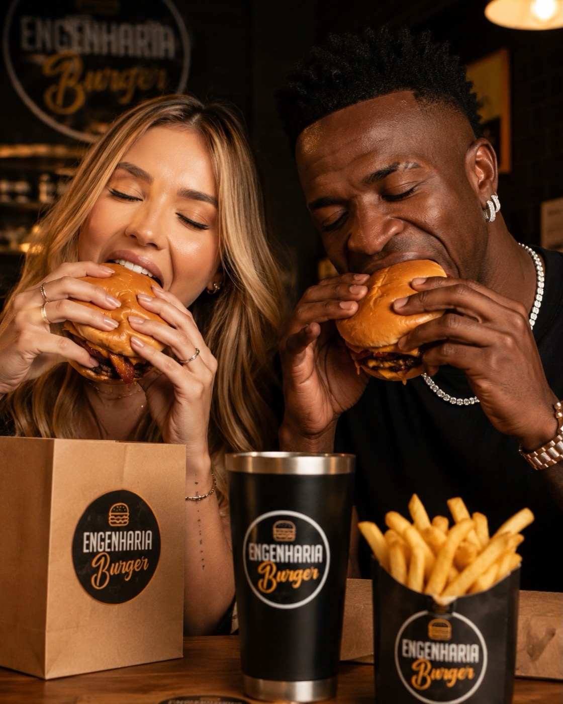 Clientes comendo burgers com embalagem da casa