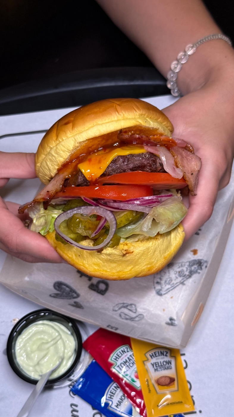 Burger aberto mostrando camadas de queijo e salada